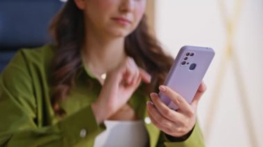 Öğrenci akıllı telefon ekranını modern daire kapanış ekranında kaydırıyor. Ciddi bir kadın cep telefonu dokunmatik tarama uygulamasını işaret ediyor. Evde sosyal medyada haberleri izleyen yeşil tişörtlü kız..