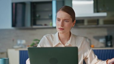 Mutlu iş kadını ev işyerinde yakın oturarak iş başarısına seviniyor. Duygusal iş kadını dizüstü bilgisayar ekranında mali rapor tutuyor. Neşeli kadın harika haberler okurken heyecanlanıyor.