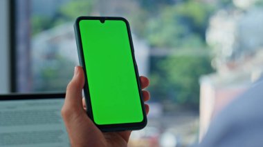 Girişimci uzaktaki iş yerinde yeşil ekran cep telefonu uygulamasını çalıştırıyor. Kimliği belirsiz erkek serbest çalışan yeşil ekranlı akıllı telefondan sosyal medyayı izliyor. İş adamı iş için cep telefonu kullanıyor.
