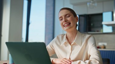 Ofisteki bilgisayarla sanal toplantıda gülümseyen bir kadın. İş kadını videosu iş arkadaşlarıyla iş stratejisini tartışıyor. Çevrimiçi konferansta konuşan pozitif kadın.