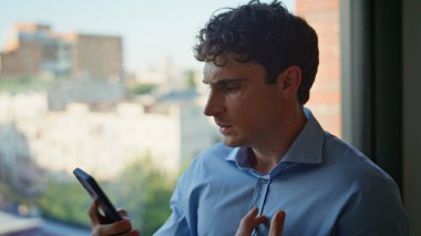 Sinirli patron, modern ofisteki iş başarısızlığından endişeleniyor. Sinirli işadamı, panoramik pencerenin önünde duran akıllı telefon konuşmasından memnun değil. Hüsrana uğramış adam stres altında..