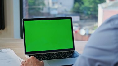 Ofis müdürü, çalışma masasında dizüstü bilgisayarı hazırlıyor. Modern iş yerinde oturan yeşil ekran bilgisayarda bilinmeyen bir adam serbest internet sitesinde geziniyor. İşadamı krom tuşlu dijital aygıtı izliyor.