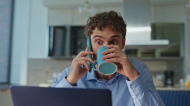 İş yerinde cep telefonuyla konuşan, kahve içmekle meşgul bir girişimci. Genç profesyonel cep telefonunu arayıp elinde fincanla dokümanları okuyor. Kendine güveni olan bir çalışan, kapalı alanda çoklu görev yapıyor..