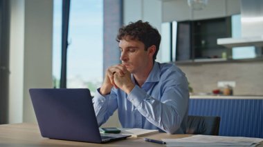 İş adamı evde otururken iş konusunda endişeli. Endişeli adam bilgisayarın kapağını kapatıyor duygusal olarak tatminsiz iş başarısızlığı. Kızgın erkek yönetici apartman mutfağında iş krizi düşünüyor..