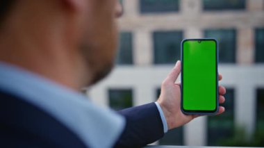 Şehirde dikey kromakey cep telefonuyla el ele tutuşmak. Kimliği belirsiz bir adam yeşil ekran cihazını izlerken e-posta okuyor. Şehir merkezinde isimsiz bir yönetici dinleniyor. Erkek patron görünümlü.