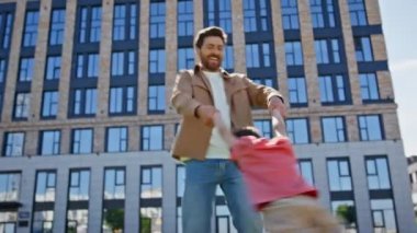 Kaygısız baba oğul girdap halinde yeşil bir mahallede yakın plan. Sakallı mutlu adam parkta küçük çocukla dönüyor. Rahat, pozitif baba, küçük çocuk dışarıda oynarken eğleniyor. Çocukluk kavramı