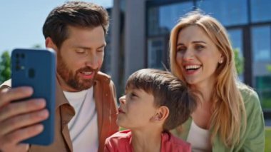 Mutlu aile videoları, doğadaki akıllı telefonları kapatıyorlar. Gülümseyen ebeveynler küçük çocuk yaz pikniğinde webcam mesafesi video görüşmesinin keyfini çıkarıyor. Neşeli anne, baba, küçük çocuk dışarıda akrabalarla konuşuyor. 