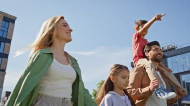 Mutlu nesiller güneş parkında yürüyüp tatilin tadını çıkarıyor. Küçük sırtımda taşıdığım çocuk, evin yakınındaki tarlada ailesiyle konuşuyordu. İki kardeş kardeş hafta sonunu anne ve babayla geçiriyorlar. 