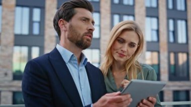 Neşeli iş adamları yüksek binanın arka planında duran iş yerlerinden bahsediyorlar. Tabletteki iş istatistiklerini analiz eden iki şirket yöneticisi. Stratejiyi tartışan neşeli iki meslektaşım