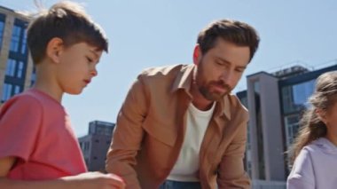 Pozitif baba açık hava çekiminde meyvelerle hokkabazlık yapar. İlgilenen çocuk numaralara bakıyor. Gülümseyen kadın çocuklar yeşil bölgede piknikte birlikte eğleniyorlar. Çocukluk yaşam tarzı konsepti