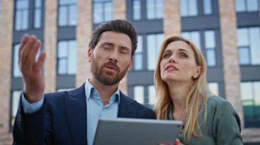 İş ortakları, mimar mekanında tablet planlama şirketinin büyümesini tartışıyor. Stratejiyi analiz eden güvenilir meslektaşlar modern ofis inşaatında sekmeyle birlikte konuşuyorlar.