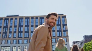 Yeşillik alanda birlikte yürüyen ebeveynler. Gülümseyen baba, yeşil çayırda küçük oğlunu kendine çekiyor. Mutlu mutlu aile el ele tutuşup yazlık çimlerin yanına yerleşiyor.