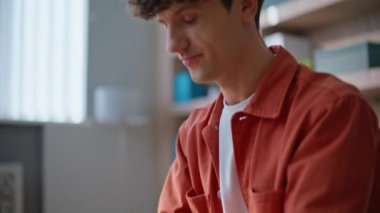 Uzak iş yerlerinde başarılı olacağını öngören bir girişim üzerine profesyonel bir çalışma. Gülümseyen iş adamı dizüstü bilgisayarda proje yaratıyor. Daire masasında çalışan mutlu kıvırcık öğrenci..