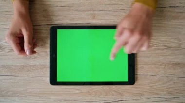 Çalışanların elleri ahşap masadan tablet araklıyor. Üst manzara kapalı. Ofisteki yeşil ekranlı bilgisayarda çalışan kimliği belirsiz bir iş kadını. Chroma Key Gadget 'ta serbest çalışan kadın web sitesi.