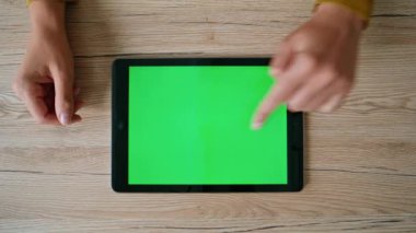 Evdeki yeşil ekran tabletteki kadın mesajını tarıyor. Üst görüntüde. Chroma Key Cihazı 'nda çevrimiçi proje yapan tanınmamış kadın serbest çalışan. Bayan yönetici ofis masasındaki maket bilgisayarında çalışıyor.
