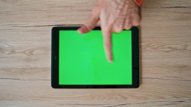 Müşteri alışverişi tablet tıkırtısıyla ahşap masada sergileniyor. Bilinmeyen adam çevrimiçi alımı Chroma Key Cihazından seçiyor. Evde yeşil ekranlı bilgisayar araklayan serbest yazar.