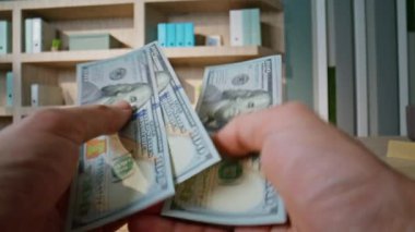 Ofiste banknotları sayan bir iş adamı. Profesyonel çalışma alanında iş anlaşması için para tutan tanınmamış zengin bir adam. Girişimci mali yatırım için para hesaplıyor.