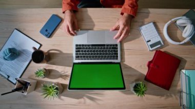 Modern ev işyerinde oturan öğrenci yeşil ekran laptop 'a göz atıyor. Chroma Key Cihazı 'nda çalışan serbest çalışan biri. Bilinmeyen işadamı elleri çevrimiçi bilgisayar uygulamasını açıyor.