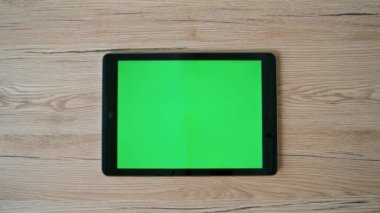 Ofis masasında yeşil ekran tableti araklayan el. Bilinmeyen iş kadını masadaki Chroma Key Pad bilgisayarında bankacılık uygulamasına göz atıyor. İş yerindeki dijital cihazda çalışan serbest çalışan bir kadın..