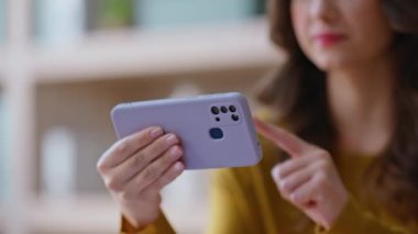 Kız elinde yatay cep telefonu ile ekranda video izliyor. Gülümseyen kadın cep telefonuyla evde rahat oturarak oyun oynuyor. Neşeli iş kadını akıllı telefon sosyal medya içeriğini araştırıyor