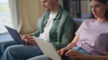 Kapanış serbest çalışanların elleri kanepede oturan dizüstü bilgisayarlarda çalışıyor. Diz çöküp birbirlerine gülümseyen mutlu bir çift. Kanepede birlikte klavye yazma çifti 