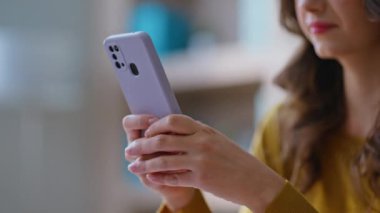 Ofiste çalışan bir kadın cep telefonuna mesaj atıyor. Yakın çekim. Modern çalışma alanında oturan akıllı telefondan iş mesajı yazan genç bir iş kadını. Cep telefonu uygulaması ile çevrimiçi sipariş veren uzak yönetici