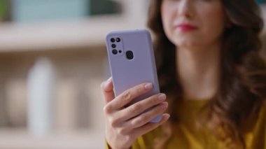 Modern apartmandaki cep telefonunun içeriğine göz atan bir kız. Modern akıllı telefondan el ele tutuşan bir kadın ofis telefonundan mesaj okuyor. İş yerinde cep telefonu ekranına bakan genç bir iş kadını.