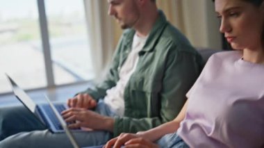 Uzaktan kumandalı yöneticiler evde çalışan dizüstü bilgisayarları tıkırdatıyor. Kanepede fikir alışverişinde bulunan iki iş kadını. Yorgun çift bilgisayarların başında çalışıyor.