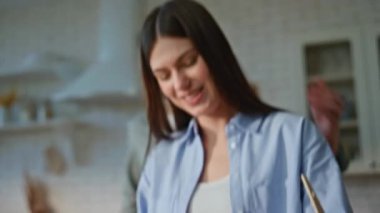 Kadın elleri vejetaryen yemeği için dolma biber kesiyor. Yakışıklı koca, sevgili karısını neşeyle besliyor. Gülen kadının sevgi dolu bir adamla eğlenmesine şaşıyorum. Hoş bir ev hayatı.