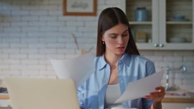 Mutfak işyerinde çalışan yorgun bir kadın belgeyi inceliyor. Tatminsiz iş kadını dizüstü bilgisayarda hata arıyor. Stresli kadın iş sorunu yüzünden gergin.