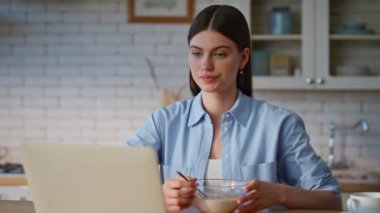 Ev hanımı dizüstü bilgisayarı mutfakta çay yudumluyor. Sakin kadın serbest çalışan kahvaltının tadını ev mutfağında çıkarıyor. Evde internetten bilgi okuyan mutlu kız öğrenci. 