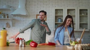 Aile dansı mutfağını kapatıyoruz. Gülümseyen koca eşi vejetaryen salatası hazırlarken eğleniyor. Mutlu romantik çift taze sebzelerle dolu tezgahın yanında oynaşıyor.