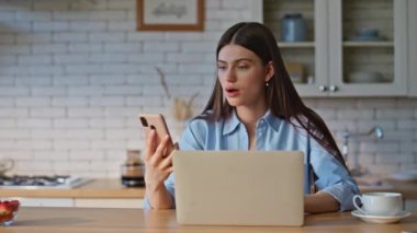 Mutfak tezgahından cep telefonunu alan üzgün kadın. Hayal kırıklığına uğramış serbest çalışan kız cep telefonunda kötü haber mesajı okuyor bilgisayar işyerinde tek başına çalışıyor. Bilgisayarı kapatan kadın kafasına dokunuyor