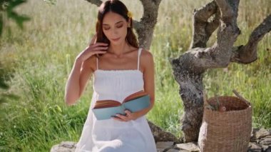 Romantik kadın güzel yeşil çimlerde tek başına oturmaktan hoşlanıyor. Düşünceli genç bayan doğayla ilgili ilginç romanlar okuyor. Bahçede edebiyat hobisi yapan zeki esmer kız.