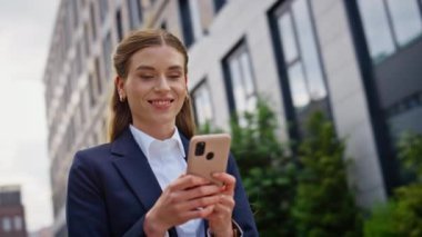 Gülümseyen yönetici şehir merkezinde akıllı telefon mesajı okuyordu. Kendine güvenen iş kadını dışarıda cep telefonuyla sohbet ediyor. Neşeli kadın şehir caddesinde cep telefonu ekranına bakıyor..