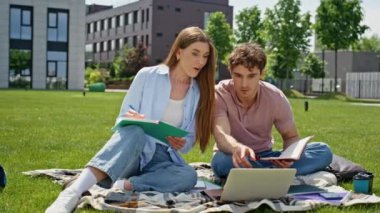 Uzaktan kumandalılar yeşil çimlerde birlikte çalışmaktan memnuniyet duyuyorlar. Dizüstü bilgisayara bakan gülümseyen kadın parkta başarıya tepki veriyor. Duygusal bağımsızlar zaferle otları kucaklıyor..