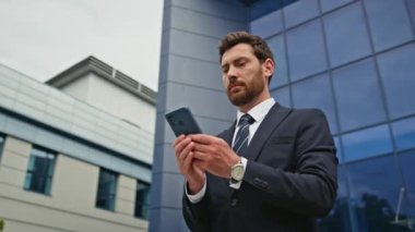 Ciddi bir yönetmen şehir merkezindeki akıllı telefonu kontrol ediyor. Odaklanmış yöneticiler cep telefonlu caddede kurumsal mesajları okuyorlar. Sakallı CEO cam mimarisinin yanındaki e-postayı okuyor..