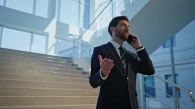 Modern ofis binasında konuşan zengin bir adam. Takım elbiseli kendine güvenen yönetici merdivenlerde telefonla konuşuyor. Şirket yöneticisi merdiven şirketinin salonundan ortakları arıyor..