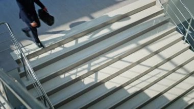 Başarılı bir işçi aşağıda kol saati arıyor. Ofis merdivenlerinden aşağı siyah evrak çantası taşıyarak koşan motive olmuş bir işadamı. Kendine güvenen bir girişimci zarif bir takım elbiseyle merdivenlerden iniyor..