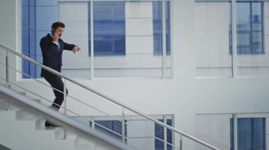 İş adamı ofis merdivenlerinde cep telefonunu kontrol ediyor. Şirketin yöneticisinin akıllı telefon konuşmalarıyla alt katta iş konuşmasından endişeleniyor. Müdür merdivenlerden inerken cep telefonuyla tartışıyor..