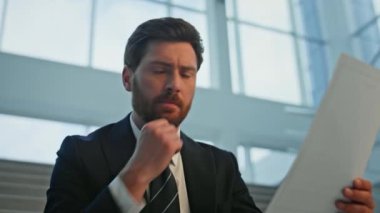 Ofis merdivenlerinde dokümanları analiz eden ciddi bir CEO. Stresli yöneticiler mali raporları inceliyor. Kayıplar konusunda endişeli. Şirket yöneticisi merdivenlerde oturmuş iş mektubu okuyor..