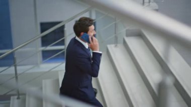 Çağrı müdürü üst kata çıkıyor çantalı modern ışık binası. Başarılı sakallı iş adamı akıllı telefondan kol saatini kontrol ediyor. Üst kata çıkan zarif girişimci şirket ofisine gidiyor..