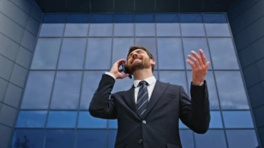 Neşeli menajer cam şehir binasının yakınında telefonla konuşuyor. Modern ofis mimarisinde gülümseyen bir işadamı cep telefonundan bahsediyor. Başarılı bir yönetici sokakta akıllı telefonla pazarlık yapıyor..