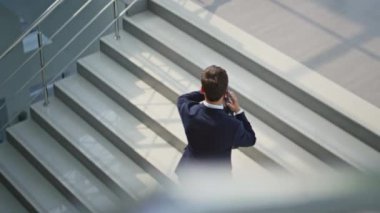 İşadamı lüks şirket ofisinde akıllı telefondan bahsederek merdivenleri tırmanıyor. Zarif girişimci akıllı telefondan arıyor. Elinde evrak çantasıyla üst kata çıkıyor. Sakallı yönetici içeride cep telefonuyla konuşuyor..