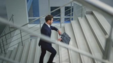 Girişimci merdivenlerden çıkıp evrak çantası taşıyor. Kendine güvenen yönetici şık bir takım elbiseyle merdivenlerden yukarı çıkıyor. Başarılı bir çalışan üst katta işe koşuyor..