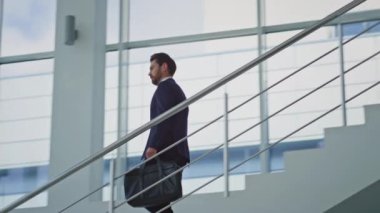 Alt katta parlak ofis binasında yürüyen zarif bir yönetici. Siyah evrak çantası taşıyan başarılı bir işadamı merdivenlerden aşağı iniyor. Orta yaşlı iş adamı kravatını düzeltiyor. Toplantıda acele ediyor..