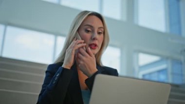 Çok görevli bir kadın cep telefonunu arıyor şirket ofisindeki merdivenlerde dizüstü bilgisayarı arıyor. Ciddi bir iş kadını akıllı telefon konuşmalarıyla rapor sunuyor. Telefonla konuşan belgeleri okumakla meşgul bir bayan yönetici.