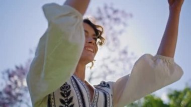 Kadın yaz pikniğine battaniye koyuyor. Lezzetli öğle yemeği için kıvırcık kadın yeşil çimlere ekose serpiştiriyor. Kaygısız kadın temiz havanın tadını çıkarıyor. Etkin dinlenme kavramı