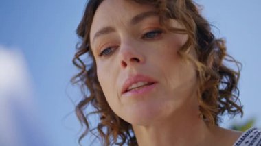 Kıvırcık kadın yazın gökyüzü arka planında kitap okuyor. Yakın plan. Yeşil Park 'ta piknik yapmaya odaklanmış bir kadın. Pozitif kadın doğası gereği eğleniyor. Rahat yaşam tarzınız kutlu olsun.