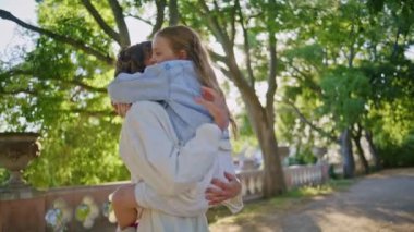Mutlu bir anne kızı büyütüyor. Sevgisini ifade ediyor. Güneşli doğada birlikte eğleniyor. Gülümseyen bir kadın, küçük tatlı bir kızı kucaklıyor ve şehir parkında aile hafta sonunun tadını çıkarıyor. Annelik anları kavramı 
